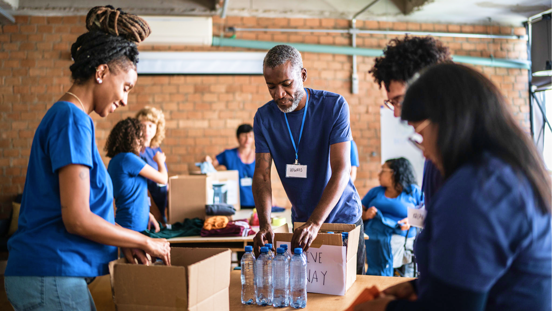 Volunteers packing supplies in community center.
