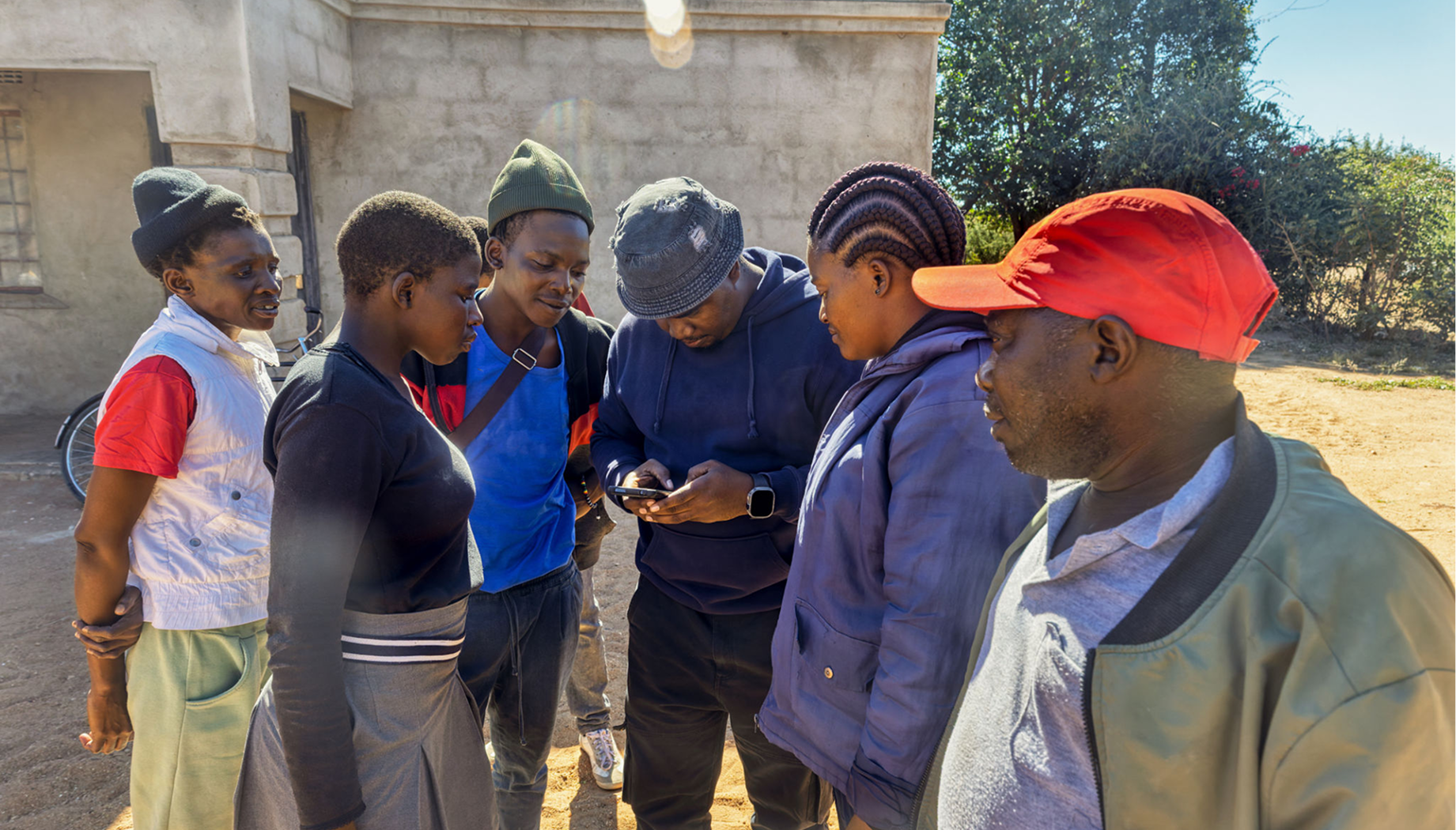 Group of people looking at a phone.